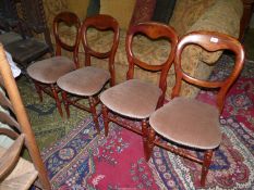 A set of four darkwood framed balloon back Chairs having turned front legs and stretchers,