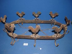 An oval wrought iron hanging Pot Rack with chicken decoration and eight large hooks.