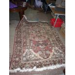 A hand knotted wool Rug with garden and temple design, slightly faded, 6' 7'' x 5' 1''.