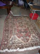 A hand knotted wool Rug with garden and temple design, slightly faded, 6' 7'' x 5' 1''.
