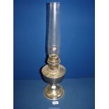 A metal based Oil lamp with glass chimney, single burner, 23'' high overall.