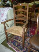 An Elm and Ashwood ladderback Armchair having a woven seagrass seat.