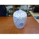 A large contemporary Oriental lidded jar with blue scrolling foliage design on white ground,