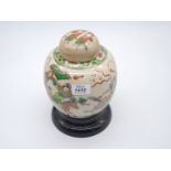 An Oriental ginger jar and lid on ceramic plinth decorated with samurai warrioers, 10" tall.