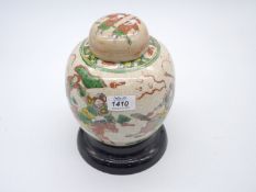 An Oriental ginger jar and lid on ceramic plinth decorated with samurai warrioers, 10" tall.