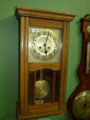 An Oak wall Clock with pendulum and key, 29" long.