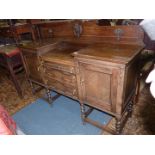 A 1930's Oak Sideboard having a central flight of three short drawers with Jacobean style moulded