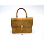 A mid 20th century cream coloured crocodile skin handbag made in England by Loewe;