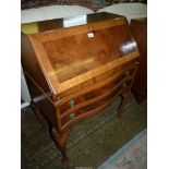 A contemporary serpentine fronted Satinwood and Walnut Bureau,