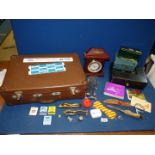 A small leather suitcase and contents including cash boxes, William Dale quartz clock,
