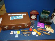 A small leather suitcase and contents including cash boxes, William Dale quartz clock,