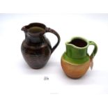 An old west country terracotta Water Jug partly glazed in green and a later studio pottery jug.