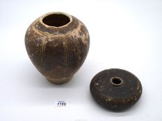 A rare Khmer pottery vase, 12th century glazed in brown with ribbed decoration, the top reduced,