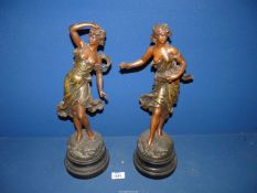 A pair of Spelter ladies on plinths, titled 'Premieres Roses', both 17'' tall.