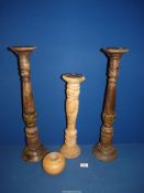 Three tall candlesticks; two dark wood and one lightwood, 24" tall.