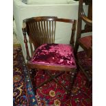 An Edwardian Mahogany framed corner Armchair having turned legs and arm supports,