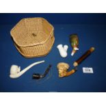 A delicately carved Meerschaum pipe in the form of a boy's head and a basket containing other pipes.