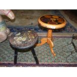 A pine occasional table with various wood grains to the top and a black wooden three legged stool