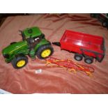 A John Deere 7930 toy tractor with red Bruder tipping trailer,
