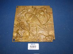 A small well cast bronze plaque depicting storks in a wetland landscape (two storks together