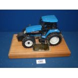 A model Ford 8970 tractor on plinth with presentation plaque.