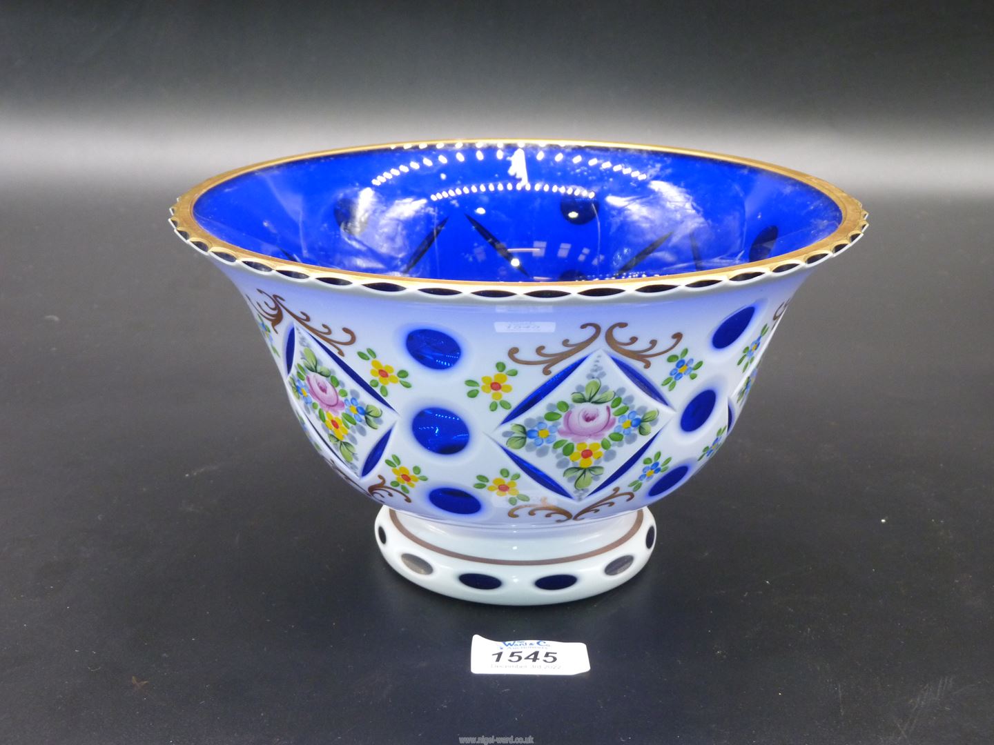 A pretty Bohemian blue glass Bowl painted with white flowers having a gilt rim,