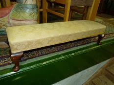 A long rectangular Footstool raised on brief cabriole legs and having beige shadow pattern