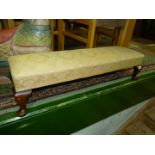 A long rectangular Footstool raised on brief cabriole legs and having beige shadow pattern