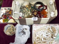 A basket of costume jewellery to include; pearls, clip-ons, bangles, etc.