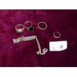 A narrow silver Identity Bracelet, three silver rings and one other.