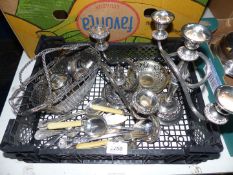 A quantity of plated items including candelabra, wine bottle holder, cutlery, napkin rings etc.