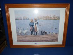 A large pine framed print of two children feeding Waterfowl by P. Nightingale.