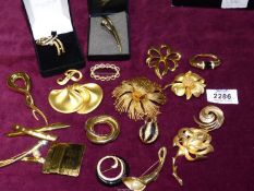 A quantity of yellow metal brooches including Givenchy, Monet, Trifari, Napier, etc.