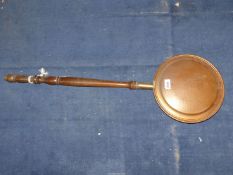 A copper and brass bed warming pan.