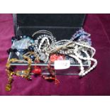 A glass jewellery casket and contents of beaded necklaces, vintage black multi-coloured necklace,