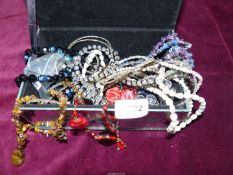 A glass jewellery casket and contents of beaded necklaces, vintage black multi-coloured necklace,