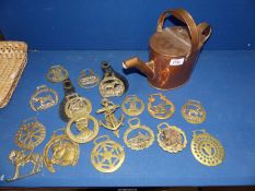 A copper watering can plus a quantity of horse brasses.