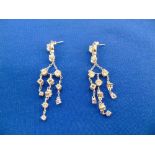 a pair of silver chandelier earrings