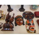 A wooden carved figure and three masks