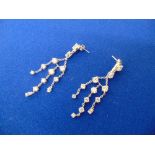a pair of silver chandelier earrings