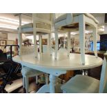 A White extending table and four white wicker chairs