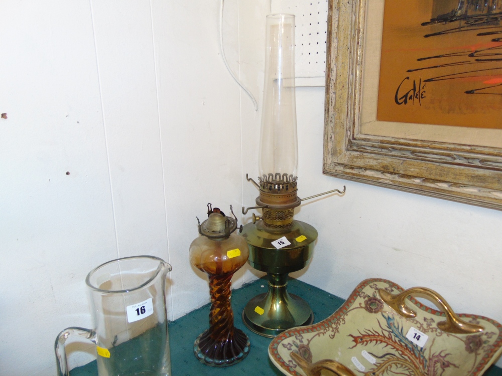 A glass oil lamp and a brass oil lamp,