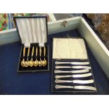 A boxed set of six Silver knives and a boxed gold plated teaspoons
