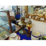 A glass oil lamp and a brass oil lamp,