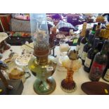 A glass oil lamp and a brass oil lamp,