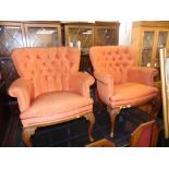 A pair of button back elbow chairs