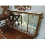 A gilt framed tryptic over mantle mirror