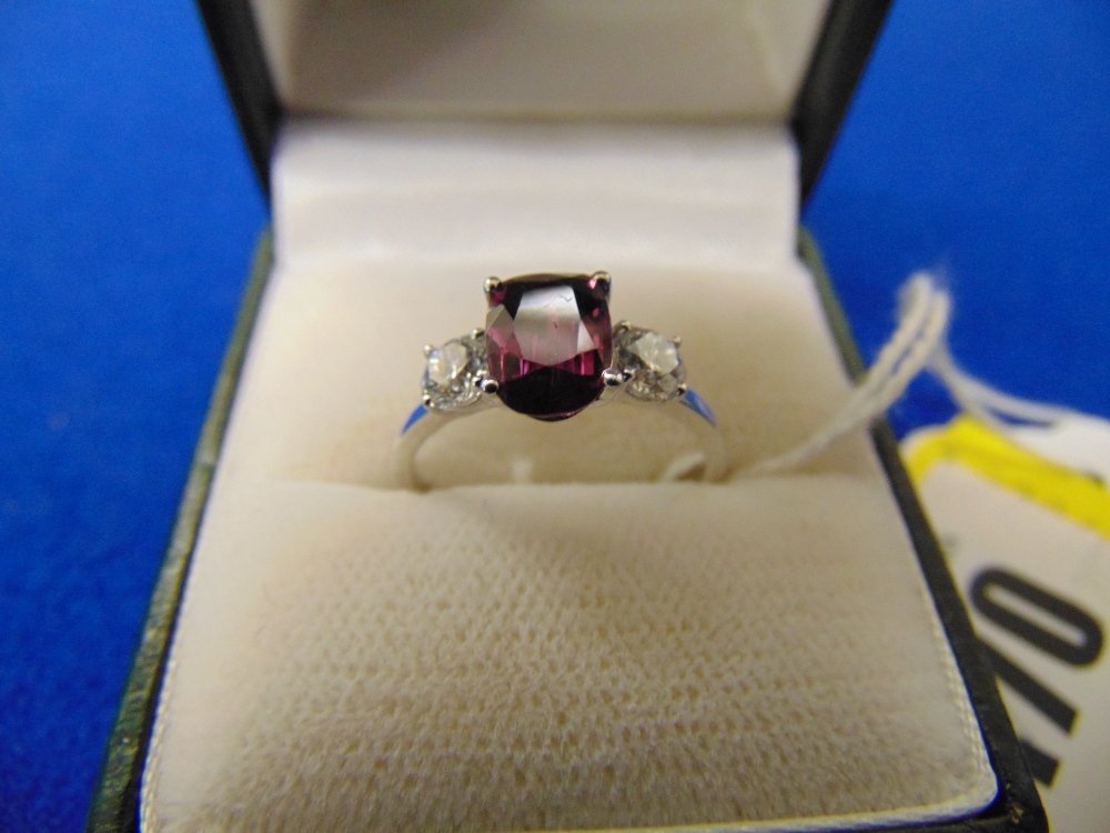 An 18ct White Gold, Sapphire (rare Amethyst Sapphire) and Diamond, three stone ring, centre stone .