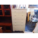 A white chest of four drawers