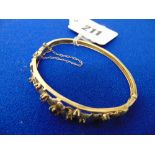 A 9ct gold Victorian bangle set with 7 garnets